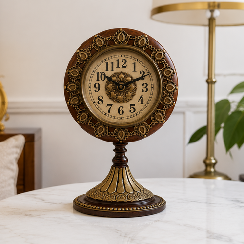 Decorative clock on a marble table with a lamp and painting in the background