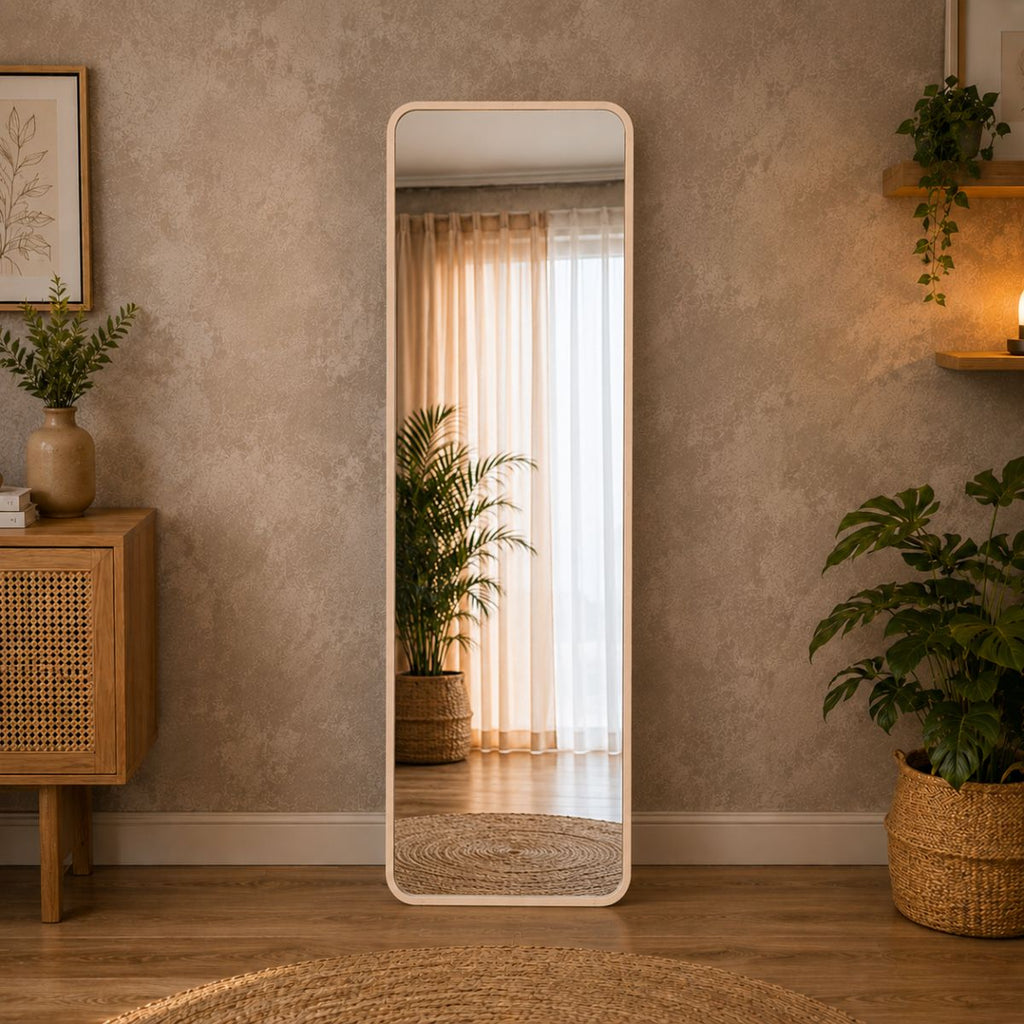 A tall, full-length floor mirror with a light aluminum alloy with beige colored frame stands in a styled room corner