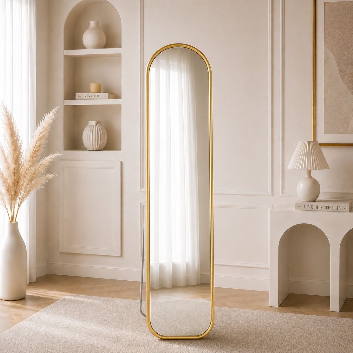 A tall floor mirror with a slim golden colored frame.